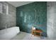 Modern bathroom with green tile accent wall, soaking tub, and wood bench at 0000 Se 17Th Ct, Ocala, FL 34471
