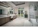 Bright bathroom featuring double vanity, soaking tub, glass shower, and large windows at 0000 Se 17Th Ct, Ocala, FL 34471