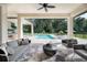 Covered patio with comfortable seating overlooking a pool and landscaped backyard at 0000 Se 17Th Ct, Ocala, FL 34471