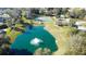 Overhead shot of a community pond with a fountain, a tennis court, and a gazebo in the background at 0000 Se 17Th Ct, Ocala, FL 34471