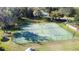 Aerial view of a tennis court and green surface, within a well-maintained community at 0000 Se 17Th Ct, Ocala, FL 34471