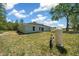 Exterior of the home shows a spacious backyard with ample green space and essential home utilities at 10435 Se 125 Ln, Belleview, FL 34420