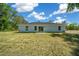 Back of the house with a large yard, sliding glass doors, and plenty of sunlight creating a relaxing atmosphere at 10435 Se 125 Ln, Belleview, FL 34420