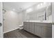 Bathroom features a double vanity, a large mirror, and a walk-in shower with stylish marble-patterned tiles at 10435 Se 125 Ln, Belleview, FL 34420