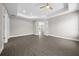 Bright bedroom featuring a tray ceiling, ceiling fan, and easy access to the home's other rooms at 10435 Se 125 Ln, Belleview, FL 34420