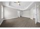 Spacious bedroom with tray ceiling, ceiling fan, and plenty of natural light streaming through the window at 10435 Se 125 Ln, Belleview, FL 34420