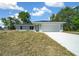 Charming single-story home featuring a two-car garage and a well-maintained lawn under a bright blue sky at 10435 Se 125 Ln, Belleview, FL 34420