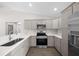Well-lit kitchen with stainless steel appliances, quartz countertops, and gray cabinets at 10435 Se 125 Ln, Belleview, FL 34420