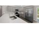 Modern kitchen with stainless steel appliances, quartz countertops, and convenient access to the backyard at 10435 Se 125 Ln, Belleview, FL 34420