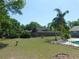 Spacious backyard features a swimming pool, mature trees, and a wood fence providing privacy at 1069 Se 57Th Ave, Ocala, FL 34480