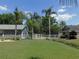 Private fenced backyard featuring well-manicured lawn and lush palm trees creating a serene retreat at 1069 Se 57Th Ave, Ocala, FL 34480