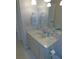 Classic bathroom with a neutral vanity, white fixtures, and a large mirror at 1069 Se 57Th Ave, Ocala, FL 34480