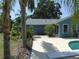 Backyard patio with blue siding house, lush tropical landscaping, and ample space for outdoor activities and relaxation at 1069 Se 57Th Ave, Ocala, FL 34480