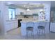 Open kitchen with bar seating, white cabinets, and tile countertops, seamlessly connected to the living area at 1069 Se 57Th Ave, Ocala, FL 34480