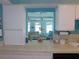 Bright kitchen area with tiled countertops and views to the open concept living space with an abundance of natural light at 1069 Se 57Th Ave, Ocala, FL 34480