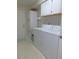 This laundry room includes a washer, dryer, storage cabinets, and a utility sink at 1069 Se 57Th Ave, Ocala, FL 34480