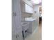 Bright laundry area boasts cabinetry, utility sink, and appliances near a doorway at 1069 Se 57Th Ave, Ocala, FL 34480