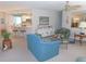 Cozy living room featuring neutral carpet, ceiling fan, and adjacent breakfast bar with seating at 1069 Se 57Th Ave, Ocala, FL 34480