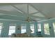 Light-filled living room with vaulted ceilings, ceiling fan, comfortable seating, and expansive windows overlooking the backyard at 1069 Se 57Th Ave, Ocala, FL 34480