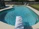 Swimming pool with crystal clear water has diving board, ladder, and manicured landscaping at 1069 Se 57Th Ave, Ocala, FL 34480