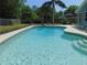 Sparkling pool water and tiled edge with landscaping offers backyard enjoyment and complements the home at 1069 Se 57Th Ave, Ocala, FL 34480