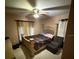 Comfortable bedroom featuring a large bed, ceiling fan, and cozy chair with storage at 10999 Sw 47Th Ave, Ocala, FL 34476