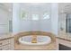 Inviting tub surrounded by granite countertops and tiled walls offers a relaxing experience at 1103 Se 46Th St, Ocala, FL 34480