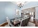 Formal dining room with elegant chandelier, wainscoting, and a view into the living room creating an open, connected space at 1103 Se 46Th St, Ocala, FL 34480