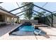 Stunning screened-in pool and spa area featuring waterfall features and an outdoor kitchen at 1103 Se 46Th St, Ocala, FL 34480
