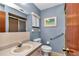 Well-lit bathroom with walk-in shower, blue walls, and grab bars at 11118 Sw 76Th Ave, Ocala, FL 34476