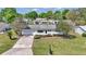Inviting home featuring blue shutters, a well-manicured lawn, mature landscaping, and an attached two-car garage at 11118 Sw 76Th Ave, Ocala, FL 34476