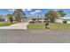 Inviting front yard featuring a driveway, green lawn, mature landscaping, and an attached two-car garage at 11118 Sw 76Th Ave, Ocala, FL 34476