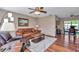 Inviting living room featuring hardwood floors, a comfortable seating arrangement, and a ceiling fan at 11118 Sw 76Th Ave, Ocala, FL 34476
