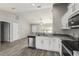 Bright kitchen featuring white cabinetry, stainless steel appliances, and views into the open living area at 11887 Se 71St Ave, Belleview, FL 34420