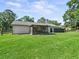 Spacious backyard showcasing well-maintained grass, a screened-in porch, and a fenced perimeter at 13897 W Highway 328, Ocala, FL 34482