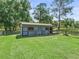 Exterior view of a well-maintained barn on a lush green lawn, surrounded by fencing at 13897 W Highway 328, Ocala, FL 34482
