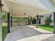 Open carport features a spacious concrete pad, black support columns, and a tongue-and-groove plank ceiling at 13897 W Highway 328, Ocala, FL 34482