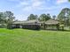 Expansive green backyard with a fenced in horse paddock and a covered horse run-in at 13897 W Highway 328, Ocala, FL 34482