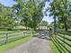 View of a home with a long driveway, mature trees, and well-maintained landscaping at 13897 W Highway 328, Ocala, FL 34482