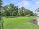 Expansive front yard showcasing well-maintained grass and mature trees at 13897 W Highway 328, Ocala, FL 34482