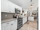 Well-equipped kitchen featuring stainless steel appliances, white cabinets, and a modern backsplash at 13897 W Highway 328, Ocala, FL 34482