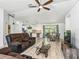 Open-concept living room with a modern ceiling fan, tile floors, and a seamless flow into the kitchen at 13897 W Highway 328, Ocala, FL 34482