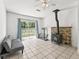 Living room featuring a rustic wood burning fireplace, large windows and a sliding glass door at 13897 W Highway 328, Ocala, FL 34482