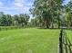 Open pasture with green grass and mature shade trees, fenced perimeter, and horse trails at 13897 W Highway 328, Ocala, FL 34482