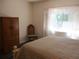 Bright bedroom featuring a comfortable bed, wardrobe, and a large window with curtains at 14244 Sw 115Th Cir, Dunnellon, FL 34432
