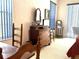 Bedroom with blue window coverings, a dresser with mirror and view of other furniture at 18956 Sw 93Rd Loop, Dunnellon, FL 34432
