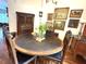 A wooden dining room table is adorned with flowers and surrounded by vintage paintings at 18956 Sw 93Rd Loop, Dunnellon, FL 34432
