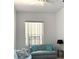 Bright living room with comfortable striped couches and natural light through the windows at 18956 Sw 93Rd Loop, Dunnellon, FL 34432
