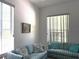 Bright living room with comfortable striped couches and natural light through the windows at 18956 Sw 93Rd Loop, Dunnellon, FL 34432