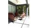 Cozy screened porch with comfortable seating and serene views of the surrounding trees at 18956 Sw 93Rd Loop, Dunnellon, FL 34432